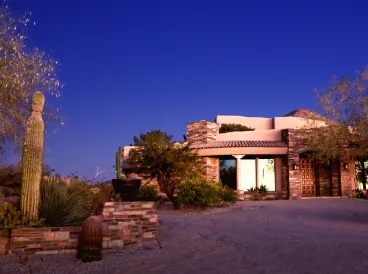Desert-style home at dusk with cactus landscaping